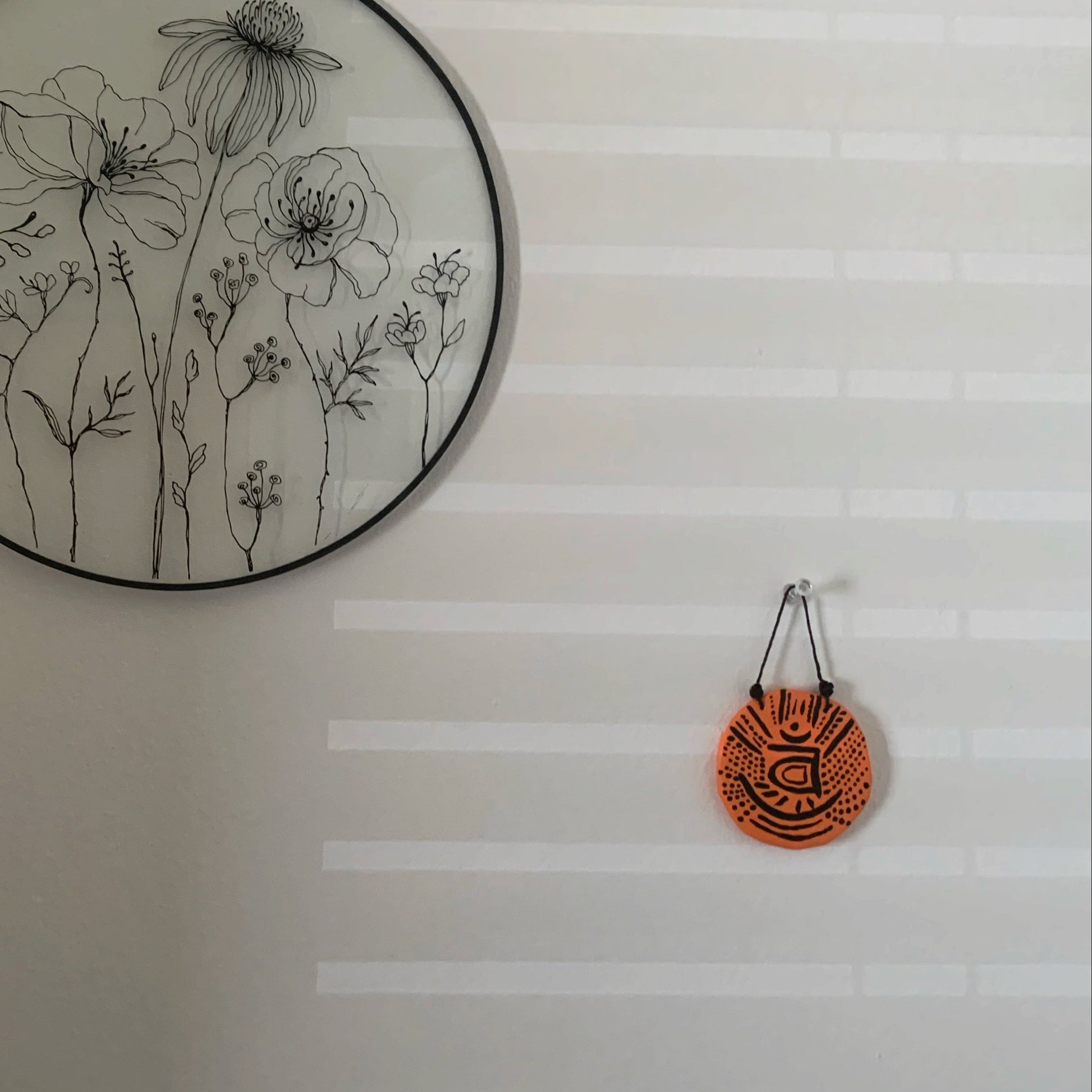 Decorative wall art with floral design on a white wall.